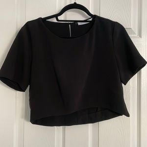 Emma & Jenna black crop top with wide short sleeves and slit in the back